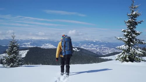 Lone Hiker Walking Through Snowy Winter Mountainscape