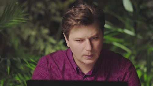 Angenehme Überraschung eines jungen attraktiven Mannes zu Hause am Computer