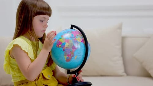 Girl Exploring Globe in Home