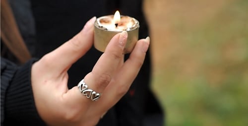 Holding Small Candle Outdoors after Flame is Extinguished