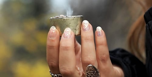 Hand Holding Lit Candle Outside