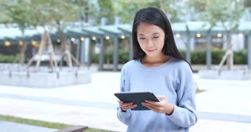 Woman Using Tablet in Urban Park
