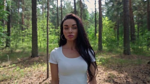 Frau steht in einem Wald