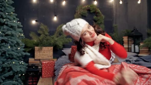 Happy Woman Lying in Decorated Bed at Christmas