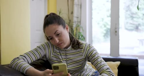 Woman Looking Concerned While Viewing Phone