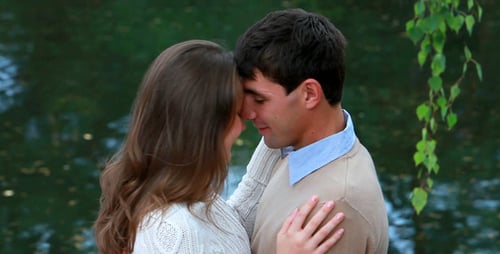 Romantic Couple Kissing and Embracing by a Lake