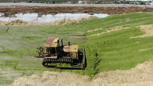 Aerial Shot of Two Bulldozers Riding on a Silo Storage on a Sunny Day in Summer