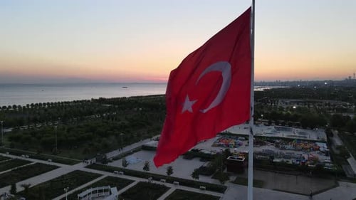 Waving Flag Over Urban Park at Sunset