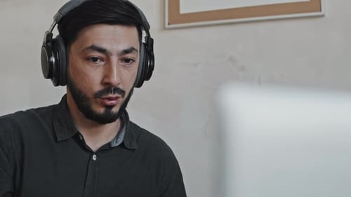 Man in Headphones Participating in Video Call