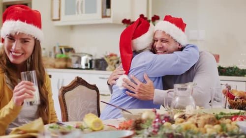 Christmas Family Hug at Holiday Dinner Table