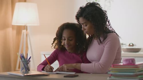 Child Doing Homework With Adult Assistance