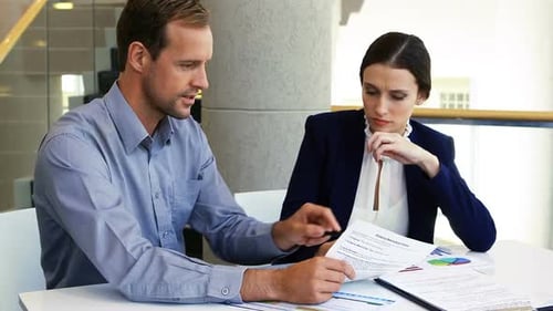 Business Professionals Discussing Financial Documents in Office