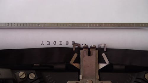 Typing alphabet letters A B C D E F on retro typewriter. Close up.