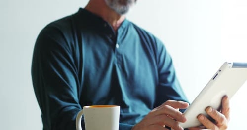 Person With Gray Hair Uses Tablet Indoors