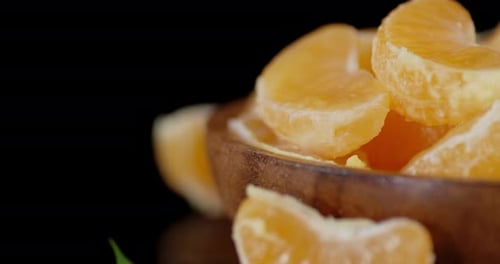 Slices of Ripe Tangerine on a Wooden Plate Slowly Rotate.