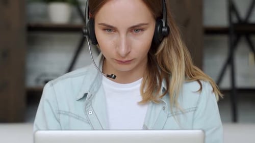 Attentive Young Adult Working from Home with Headset