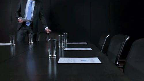 Professional Man Reviews Documents at Conference Table