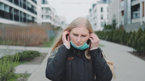 Woman Putting on a Medical Mask While Going on the Street