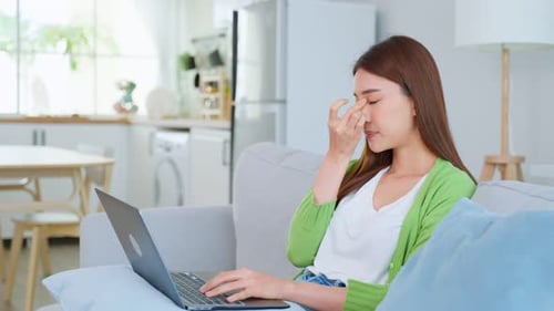 Woman Working At Home Rubbing Eyes