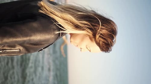 Woman with Blonde Hair and Leather Jacket at Beach