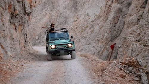 Woman Explores Rugged Terrain in Open Topped Jeep