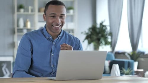 Smiling Young Adult Using Laptop for Video Call