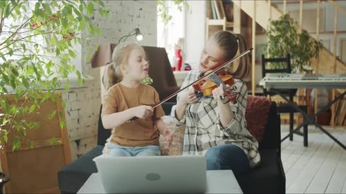 Woman and Child Playing Violin Together at Home