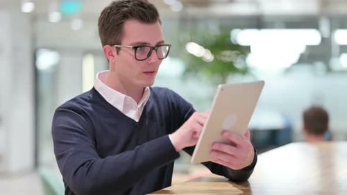 Young Adult Uses Tablet in Office Setting