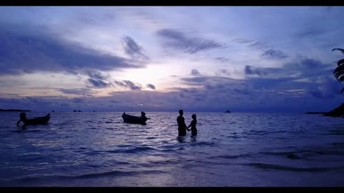 Two people engaged on tranquil resort beach trip by transparent lagoon and bright sand background of