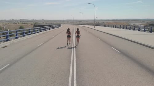 Two Women Running on Bridge Aerial Shot