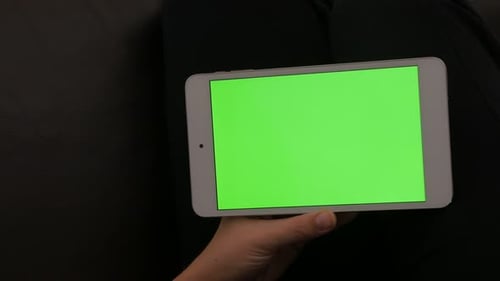 Woman resting at home and holding green screen chroma key tablet 4K 2160p 30fps UltraHD footage - Yo