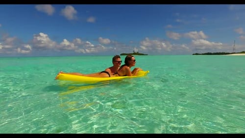Young couple suntan on relaxing coast beach vacation by blue green ocean and white sandy background