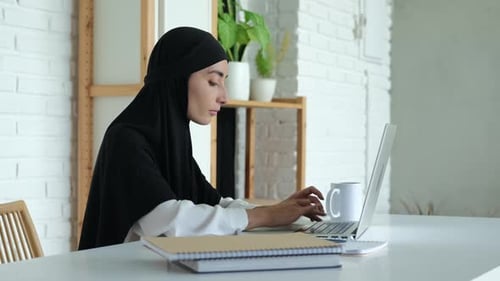 Young Woman Working on Laptop at Home