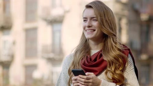 Smiling Woman Using Smartphone Outdoors
