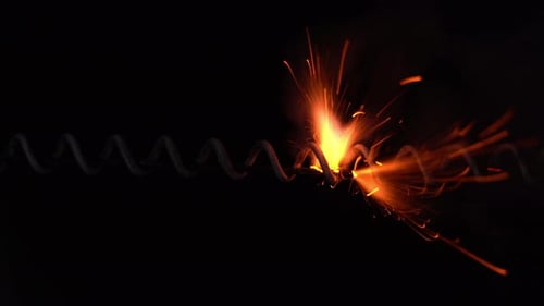 Orange Sparks Erupting from a Spiraled Gray Wire
