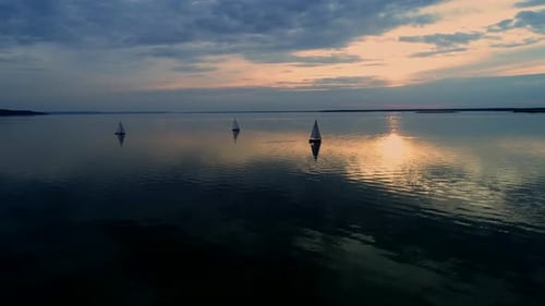 Sailboats Silhouetted at Sunset on Quiet Water