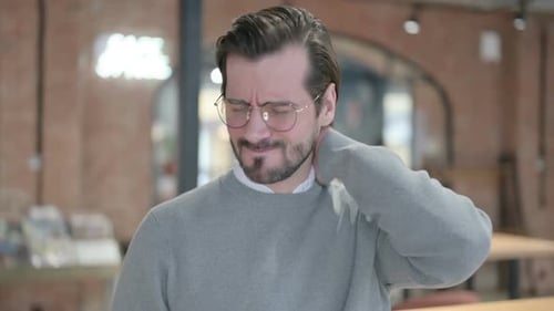 Man Rubs Stiff Neck Due to Pain