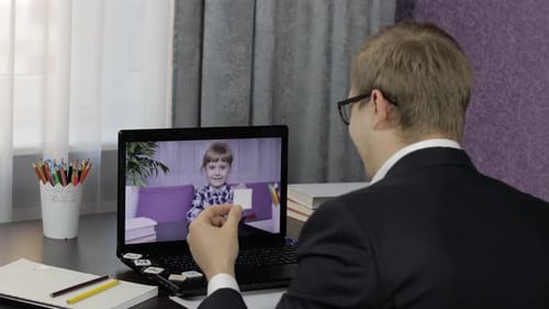 Man Video Calls Child on Laptop From Home