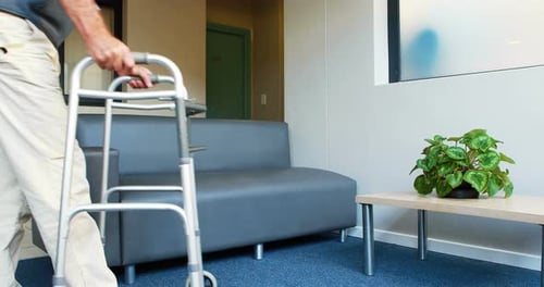 Patient helping himself to have a sit thanks to his zimmer frame