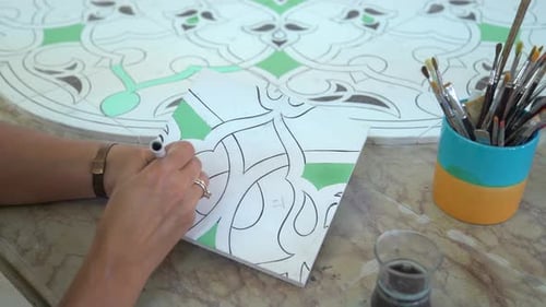 Woman Tracing Intricate Tile Design