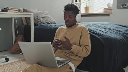 Young Adult Video Conferencing on Laptop in Bedroom
