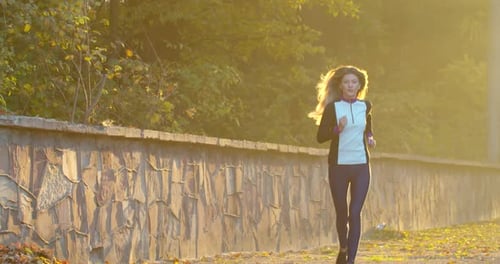 Woman Running in the Sunny City Park. Morning Light.
