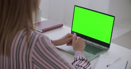 Ordenador portátil con pantalla verde para tecnología Chroma Key en la mesa de trabajo de aprendizaje o mujer trabajadora