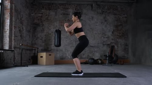 Young Indian Athletic Woman Doing Sports Doing Squat Exercise, Wearing Sportswear