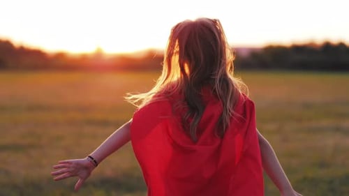 Child Runs With Cape in Sunset Field