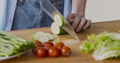 Slicing Cucumber for Salad Preparation in Kitchen