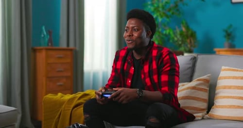 Man Plays Video Games on Couch in Living Room