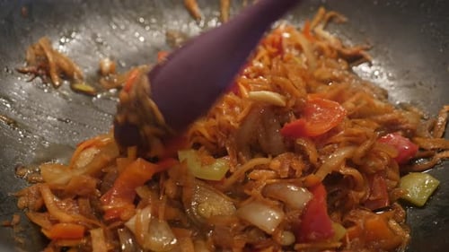 Frying of bulb onion and grated carrot 4K 2160p 30fps UltraHD footage - Frozen vegetable mix in hot
