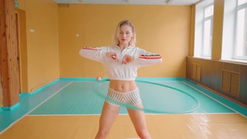 Woman Works Out with Hula Hoop in Gymnasium