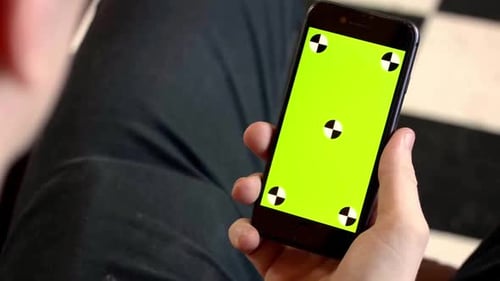 Man holding phone with green screen